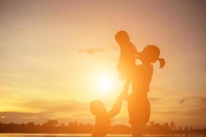 Mother encouraged her son outdoors at sunset, silhouette concept photo