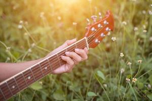 Young hipster woman playing guitar to relaxing on his holiday, enjoy with natural and fresh air. photo