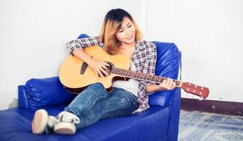 mujer joven inconformista tocando una guitarra. foto