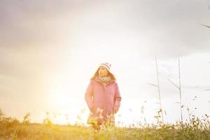 Young woman was playing in a field of flowers in the winter air. photo