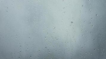 Rain drops running down a window in a close up view. video