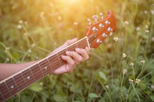 Young hipster woman playing guitar to relaxing on his holiday, enjoy with natural and fresh air. photo