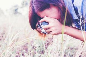 vintage de fotografía de mujeres hermosas mano de pie sosteniendo cámara retro con amanecer, estilo suave de ensueño foto