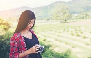 vintage de fotografía de mujeres hermosas mano de pie sosteniendo cámara retro con amanecer, estilo suave de ensueño foto