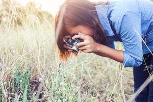 vintage de fotografía de mujeres hermosas mano de pie sosteniendo cámara retro con amanecer, estilo suave de ensueño foto