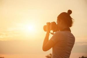 silueta fotógrafo mujer en la puesta del sol foto