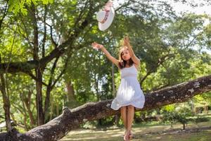 Young teen girl sitting on tree and holding balloons in hand photo
