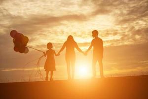 silueta de niño, momentos de alegría del niño. en la puesta de sol de la naturaleza foto