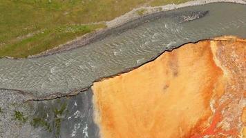 panoramica aerea dall'alto verso il basso vista ravvicinata risorse naturali minerali primaverili trame e motivi arancioni con pass per auto nella valle del truso. concetto di visite turistiche video