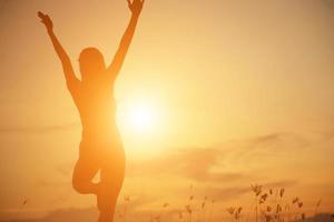 Silhouette of woman praying over beautiful sky background photo