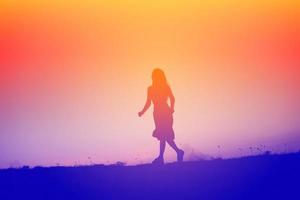 silhouette of a young woman standing alone photo