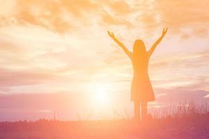 Silhouette of woman praying over beautiful sky background photo