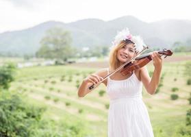 Young hipster musician woman playing violin in the nature outdoor lifestyle behind mountain. photo