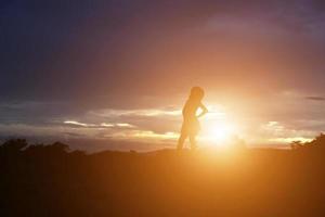 Silhouette of woman praying over beautiful sky background photo