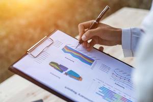 Hands of Businessman working on Laptop Computer with Data Charts photo