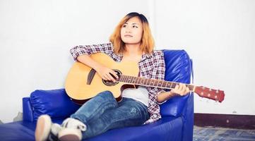 Young hipster woman playing a guitar. photo