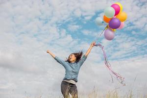 Beautiful Girl jumping with balloons on the beach photo