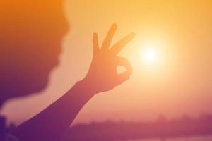 hands forming a heart shape with sunset silhouette photo