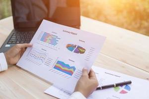 Hands of Businessman working on Laptop Computer with Data Charts photo