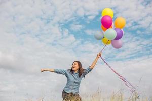 Beautiful Girl jumping with balloons on the beach photo