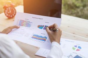 Hands of Businessman working on Laptop Computer with Data Charts photo