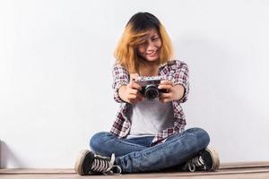 mujer joven hermosa hipster con una vieja cámara retro. foto