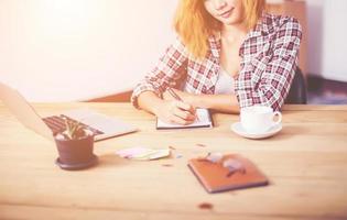 business woman writing something on notepad in office. photo