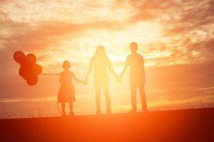 silueta de hermano y hermano, momentos de alegría del niño. en la puesta de sol de la naturaleza foto