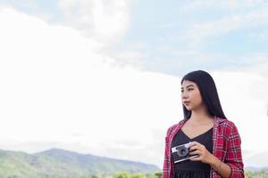 Vintage of beautiful women photography standing hand holding retro camera with sunrise,dream soft style photo