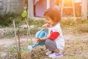 niña regando el árbol con regadera foto