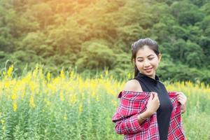 Young beautiful woman standing in the flower field enjoyment. photo