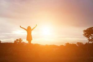 Silhouette of woman praying over beautiful sky background photo