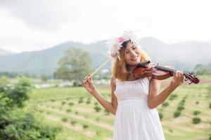 Young hipster musician woman playing violin in the nature outdoor lifestyle behind mountain. photo