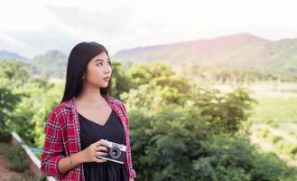 Vintage of beautiful women photography standing hand holding retro camera with sunrise,dream soft style photo