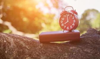 retro clock time at 8 o'clock with notebook or memo on wood table, times of memory writing diary concept vintage color tone. photo