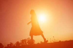 silhouette of a young woman standing alone photo