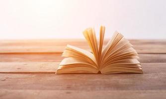 Open book on wood planks over abstract light background photo