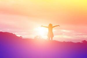 Silhouette of woman praying over beautiful sky background photo