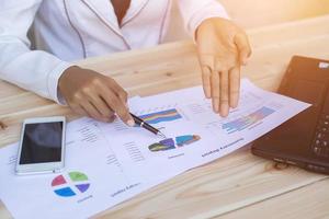 Hands of Businessman working on Laptop Computer with Data Charts photo