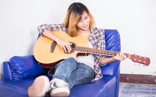 Young hipster woman playing a guitar. photo