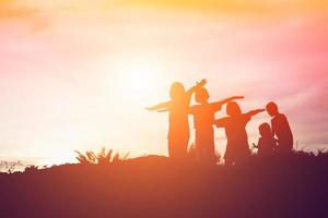 silueta de niños felices y puesta de sol feliz foto