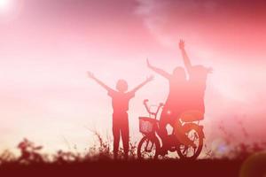 silueta de niños felices y puesta de sol feliz foto