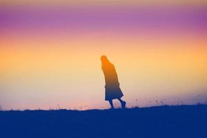 silhouette of a young woman standing alone photo