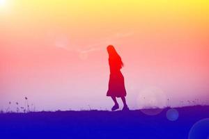 silhouette of a young woman standing alone photo