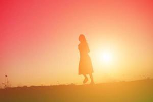 silhouette of a young woman standing alone photo