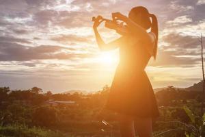 mujer joven tocando el violín con montañas en el fondo foto