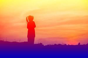 silueta de niño, momentos de alegría del niño. en la puesta de sol de la naturaleza foto