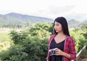 Vintage of beautiful women photography standing hand holding retro camera with sunrise,dream soft style photo