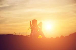 chica en la playa enviando mensajes de texto al atardecer foto