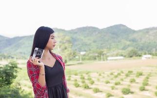 vintage de fotografía de mujeres hermosas mano de pie sosteniendo cámara retro con amanecer, estilo suave de ensueño foto